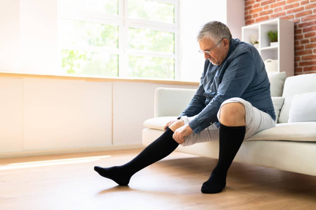 Man Putting On Medical Compression Stockings