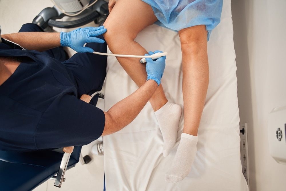 patient having their leg veins examined by their doctor with an ultrasound, before getting sclerotherapy treatment.